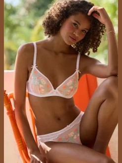 Slip féminin avec accessoire filigrane et petit nœud décoratif au centre devant
